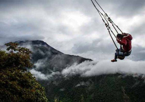 person on cable car swing over mountain in Banos , Ecuador